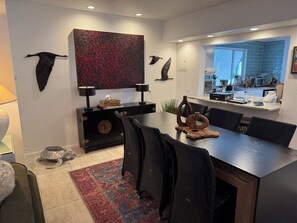 A modern dining area with a dark wood table, black chairs, and a red patterned rug. - The Pink Beach House in Delray Beach for a perfect getaway (Delray Beach)