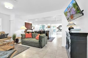 A spacious living area with a sofa, coffee table, and a flat-screen TV mounted on the wall. - The Pink Beach House in Delray Beach for a perfect getaway (Delray Beach)