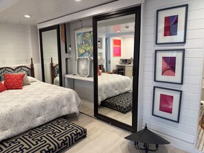 A bedroom with two beds, a large mirror, and artwork on the wall. - The Pink Beach House in Delray Beach for a perfect getaway (Delray Beach)