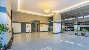 Un edificio moderno con piso pulido, una lámpara central y un estacionamiento al fondo.