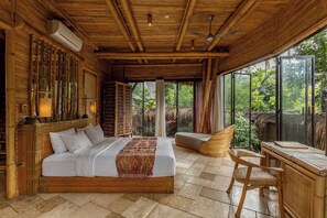 A room with a bed, a chair, a table, and a view of the outdoors. - Cacao House Eco-Luxe Family home near Green School (Kecamatan Abiansemal)