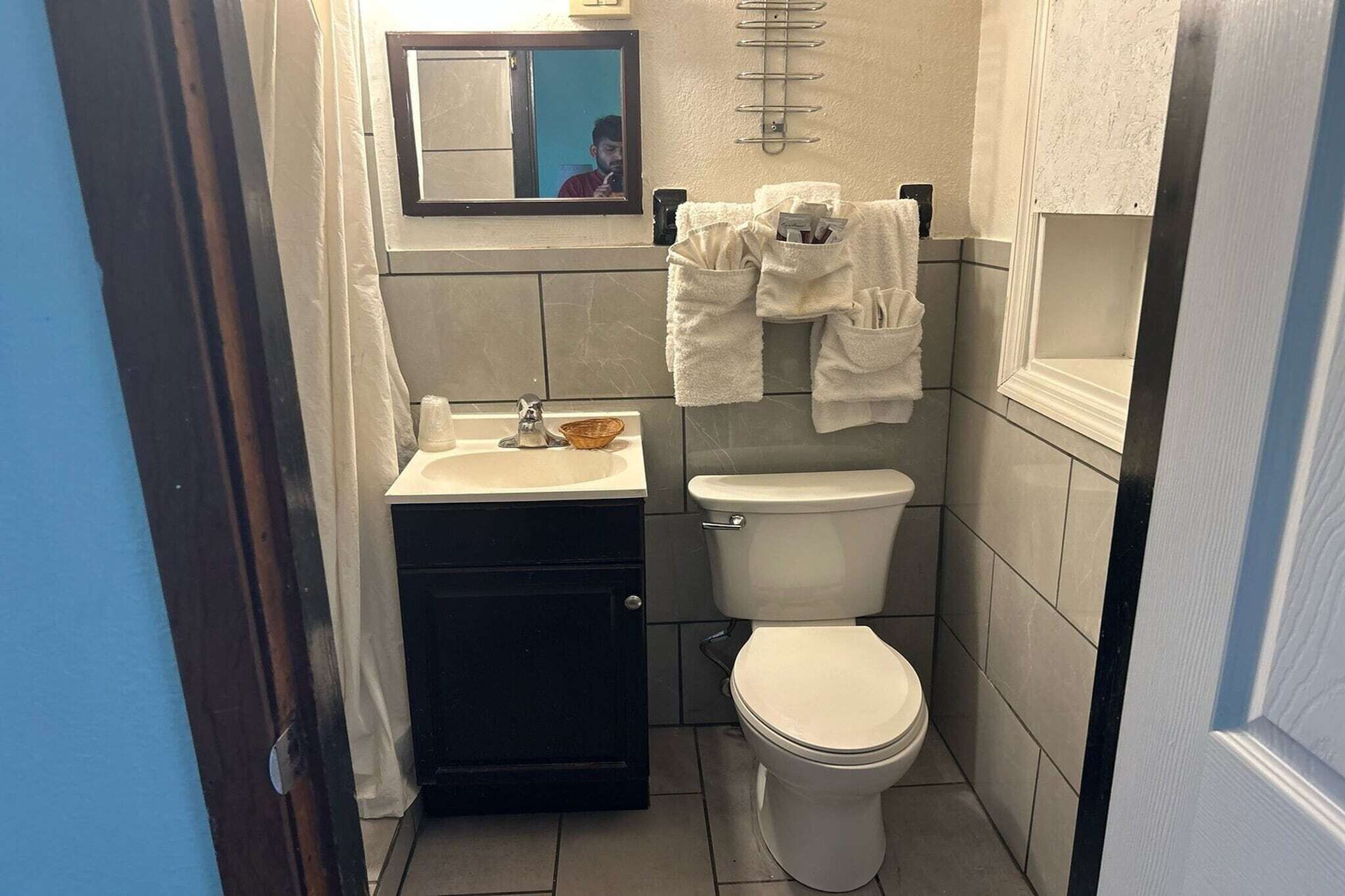 Un baño pequeño con lavamanos, inodoro y perchero para toallas.