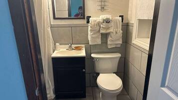 Un baño pequeño con lavamanos, inodoro y perchero para toallas.