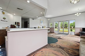 A reception area with a counter, a clock, and a sign that reads 'Relax Inn.'
