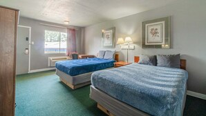 A room with two beds, a desk, a chair, and a window with curtains. - 2 Full Beds|Non-Smoking (Livingston)