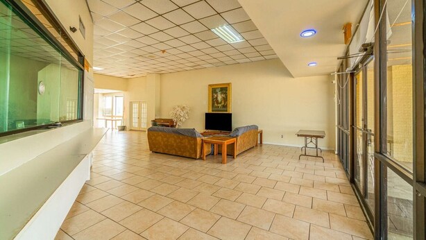 A spacious living area with a sofa set, a television, and a painting on the wall. - 2 Full Beds|Non-Smoking (Livingston)