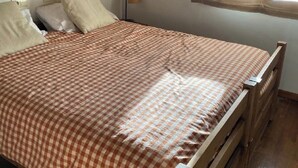 A single bed with a checkered bedspread, a bedside lamp, and a window with curtains. - Semi-detached house in Vilar dúrtx (Soriguerola)