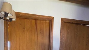Two wooden doors with a light fixture above the left door. - Semi-detached house in Vilar dúrtx (Soriguerola)
