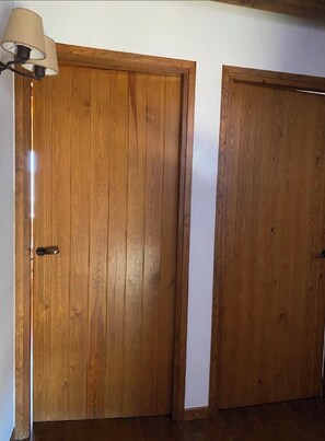 Twee houten deuren, met een lamp boven de linker deur.
