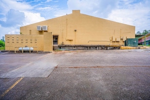 Un gran edificio industrial con techo plano, unidades de aire acondicionado y piso de concreto.