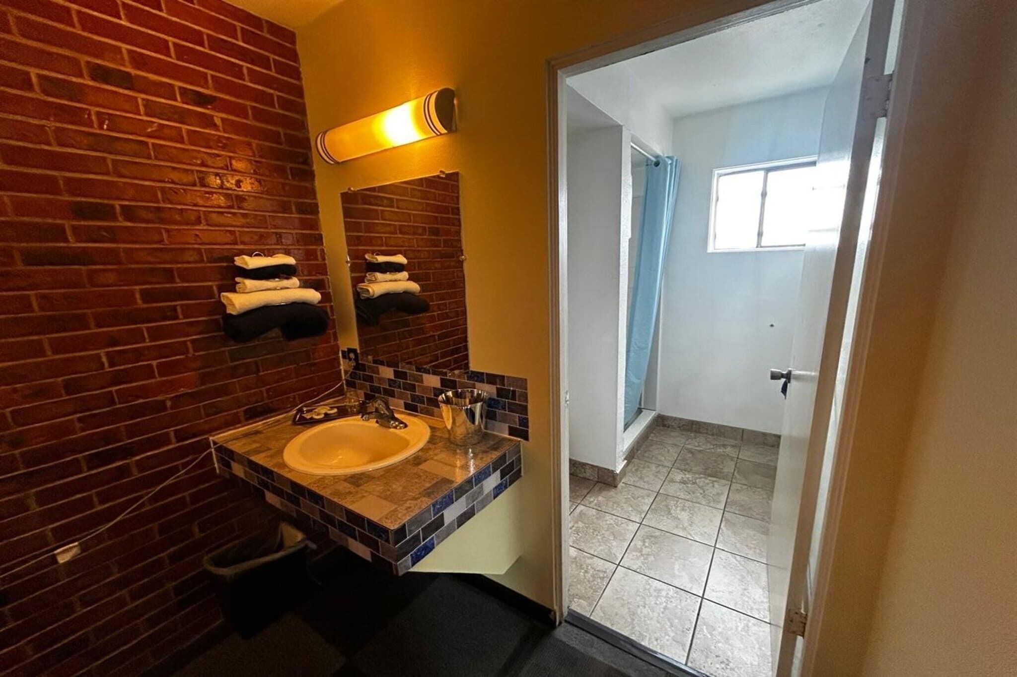 A bathroom with a sink, mirror, and towel rack.