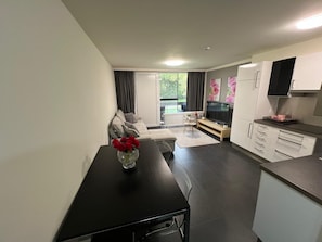 Una cocina moderna con comedor, sofá y televisor.