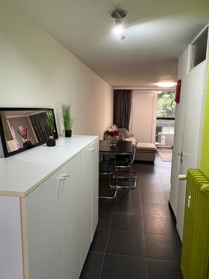 Un espacio habitable compacto con kitchenette, comedor y zona de estar con vistas al exterior.