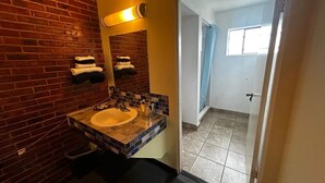 Een badkamer met een wastafel, spiegel en handdoekrek.