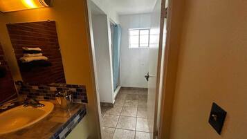 Een badkamer met een wastafel, spiegel en handdoekrek.