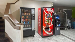 Een automaat en een pinautomaat in een openbare ruimte, met een trap.