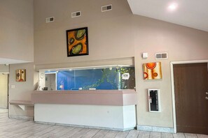 Un comptoir d’accueil agrémenté d’un aquarium, d’une horloge et d’œuvres d’art accrochées aux murs.