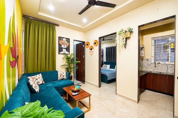 A living room with a sofa, a coffee table, and a ceiling fan.
