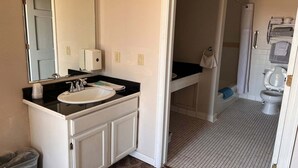Une salle de bain avec un lavabo, un miroir et un porte-serviettes.
