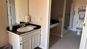 A bathroom with a sink, mirror, and towel rack. - Suite 2 Queen Beds|Non-Smoking (Miller SD)