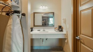A bathroom with a sink, mirror, and a hairdryer on the wall. - 2 Queen Beds|Non-Smoking (Moulton, TX)