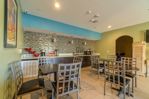 Une cuisine moderne dotée d’un îlot central, d’un coin repas avec des chaises et d’une vue sur le salon.