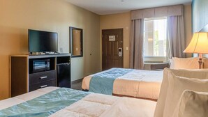 A hotel room with two beds, a television, a desk with a computer, and a window with curtains. - 2 Queen Beds|Non-Smoking (Moulton, TX)