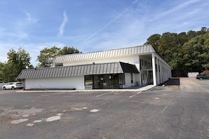 Un edifici modern amb teulada plana, grans finestres i entrada coberta.