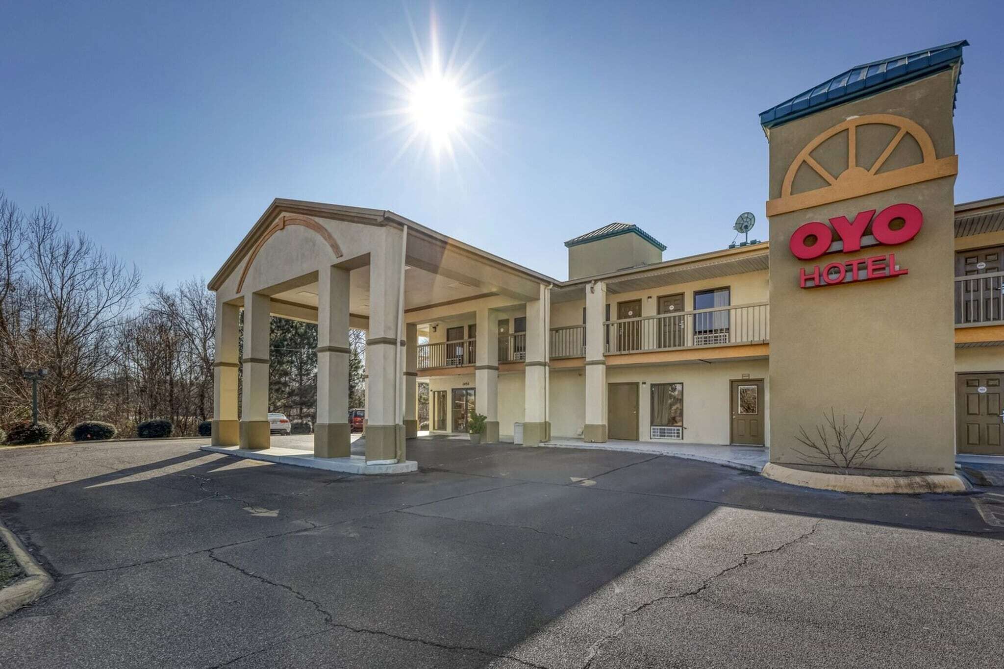 L’entrée d’un hôtel, avec un passage couvert, une enseigne indiquant « OYO Hotel » et un ciel dégagé.