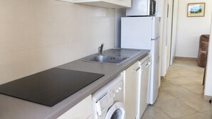 A kitchen with a sink, microwave, refrigerator, and a washing machine. - LE JASMIN 1-Bedroom Apartment, Sleeps 4 (Serra-di-Ferro)