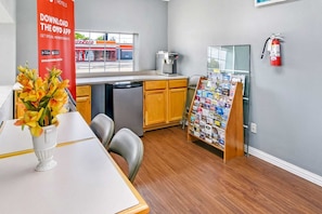 A hotel room with a kitchenette, a dining area with a table and chairs, a coffee machine, a fire extinguisher, and a bulletin board with various items. - 2 Full Bed|Smoking|Killeen TX (Killeen TX)