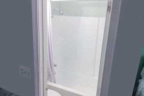 Ein Badezimmer mit einer weißen Badewanne, einer Duschvorhang und einer sichtbaren Steckdose.
