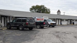 En U-Haul lastbil parkeret foran et motel med en etage og et saddeltag.