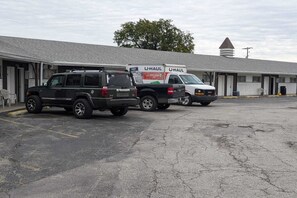 A U-Haul truck parked in front of a motel with a single-story structure and a peaked roof. - King Bed Non-Smoking (Wathena, KS)