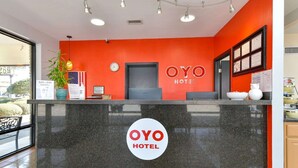 Una recepción con un logotipo, un reloj y un cartel que indica el nombre del hotel.