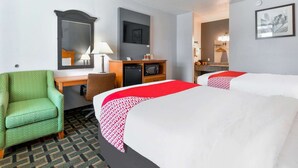 A hotel room with two beds, a desk, a chair, a TV, and a microwave.