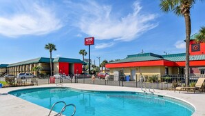 A hotel with a swimming pool, a red building, and a sign for OYO hotel.