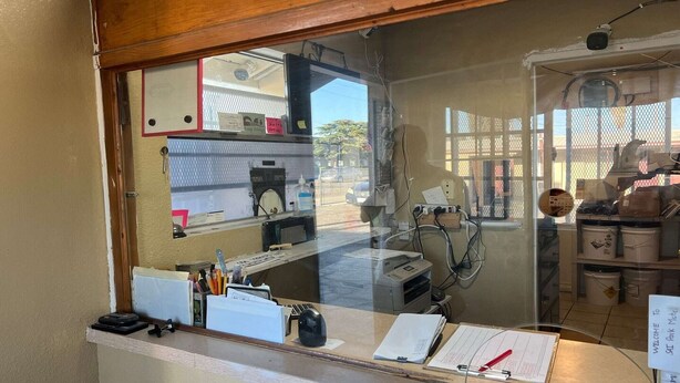 A reception desk with a computer, a telephone, and a clipboard.