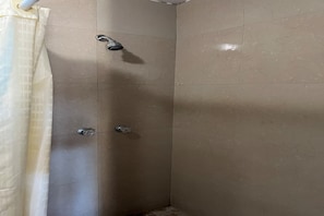Una ducha con cabezal de ducha de mano y grifo empotrado.