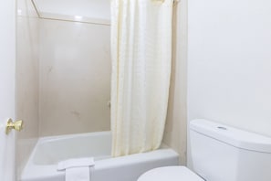 Ein Badezimmer mit Badewanne, Toilette und Duschvorhang.
