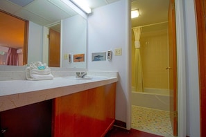 A bathroom with a sink, mirror, and shower area. - 2 Queen Beds|Non-Smoking (Liberal KS)