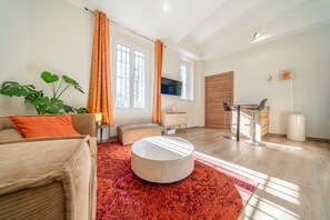 Ein modernes Wohnzimmer mit einer Couch, einem runden Couchtisch und einem Fernseher.