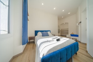Ein Schlafzimmer mit Bett, Fenster und einem blauen Vorhang.