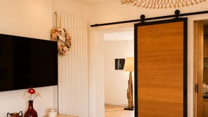 A bedroom with a bed, dresser, TV, and a sliding door. - 225 Le Club C in Cannes (Cannes)