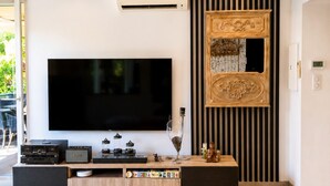 A modern living room with a large flat-screen TV, a wooden entertainment unit, and a decorative wall panel. - 225 Le Club C in Cannes (Cannes)