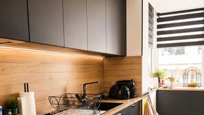 A modern kitchen with dark cabinets, a wooden countertop, and a patterned tile floor. - 225 Le Club C in Cannes (Cannes)