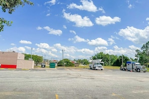 A parking lot with a large building, a utility truck, and a semi-truck.