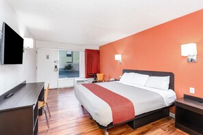 A hotel room with a bed, desk, chair, and a television. - King Bed|Non-Smoking (Columbus OH)