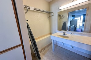 A bathroom with a white sink, a mirror, and a towel rack. - King Bed with Kitchenette Non-Smoking (Milledgeville, GA)