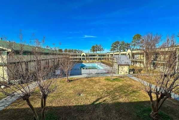 A courtyard with a swimming pool, surrounded by buildings with a simple architectural style.